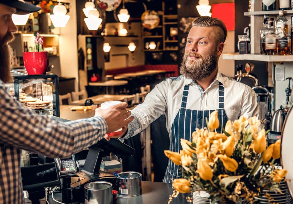 a man selling coffee to a consumer in a coffee sho 2023 11 27 05 23 39 utc