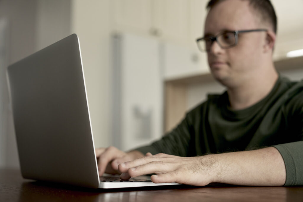 man with down syndrome using laptop at home 2024 11 25 13 43 20 utc